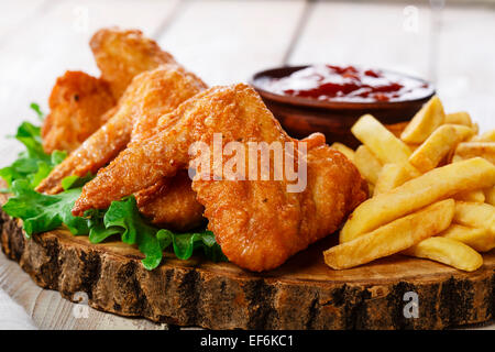 Alette di pollo fritte con salsa di pomodoro e patate fritte Foto Stock