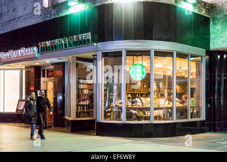 Serata presso il Lincoln Road Mall Starbucks Coffee shop con persone sedute a bere caffè interno e un paio di passeggiate sul marciapiede Foto Stock