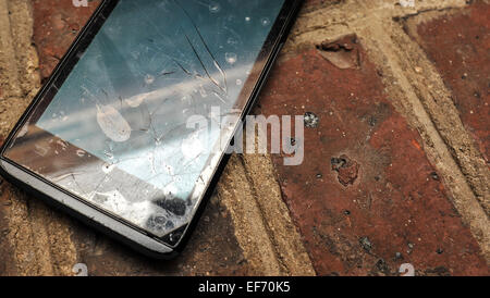 Rotture di telefono cellulare su un pavimento di mattoni Foto Stock