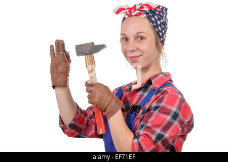 Giovane donna tuttofare guidare un chiodo con un martello Foto Stock