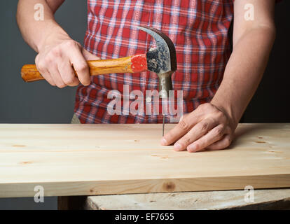 Il martellamento del chiodo per il legno di pino composizione della scheda Foto Stock