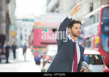 Imprenditore salutando il taxi in città Foto Stock