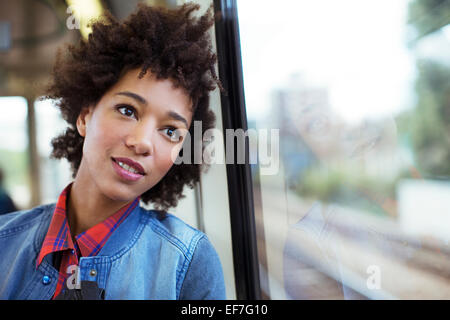 Fantasticando donna a guardare fuori dalla finestra del treno Foto Stock