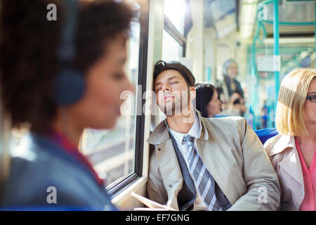 Imprenditore sonnecchiare sul treno Foto Stock