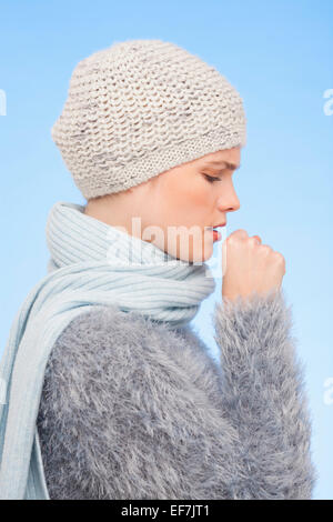Donna in berretto lavorato a maglia e la tosse Foto Stock