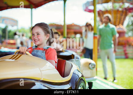 Allegro ragazza sulla giostra nel parco dei divertimenti Foto Stock