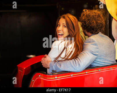 L'uomo abbracciando spaventata ragazza mentre va in tunnel in treno fantasma Foto Stock