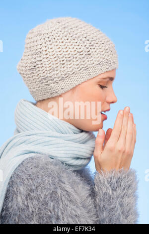 Donna in maglia hat e starnuti Foto Stock