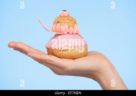 Close-up di una donna di mano che tiene un francese religieuse fragola
