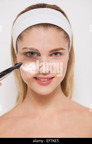 Bella donna guardando attraverso una lente di ingrandimento Foto Stock