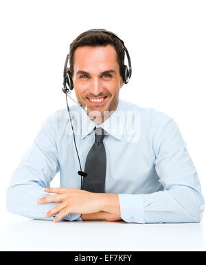 Ritratto di un uomo sorridente con cuffia appoggiata sulla sua scrivania Foto Stock