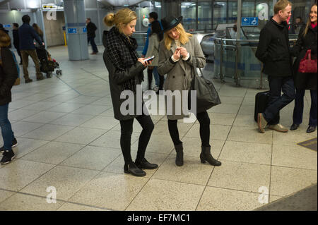 La metropolitana di Londra la stazione di Westminster, Londra Inghilterra,UK. Due giovani donne in abiti moderni. Jan 2015 Foto Stock