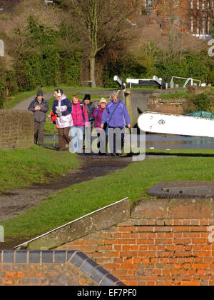 Senior Caucasian escursionisti a piedi lungo una strada alzaia a Stourbridge Canal, Wordsley, West Midlands, Inghilterra, Regno Unito in inverno Foto Stock