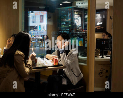 Le donne cinesi di mangiare in un ristorante McDonald's a Shanghai in Cina Foto Stock