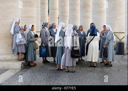 Un gruppo di suore raccolte dalle colonne del Colonnato di Piazza San Pietro, Città del Vaticano, Roma, Italia. Foto Stock