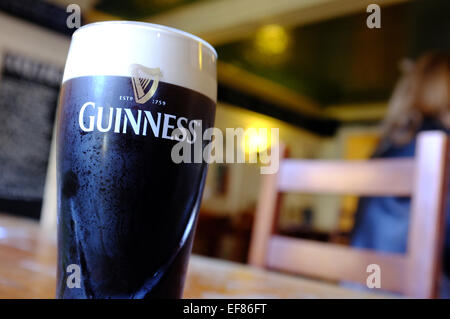 Una pinta di Guinness in un pub tavola in Brighton. Foto Stock