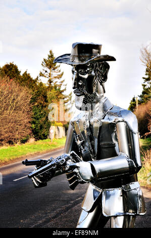 La vita di metallo di dimensioni scultura Cowboy con pistole disegnati sul ciglio della strada in East Anglia, REGNO UNITO Foto Stock