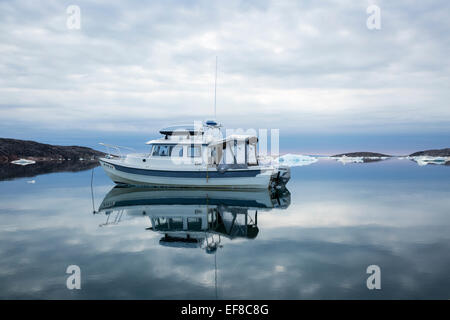 Canada, Nunavut Territorio, C-Dory imbarcazione a motore giace al di ancoraggio in acqua ferma vicino al Circolo Polare Artico durante la Baia di Hudson estate expeditio Foto Stock