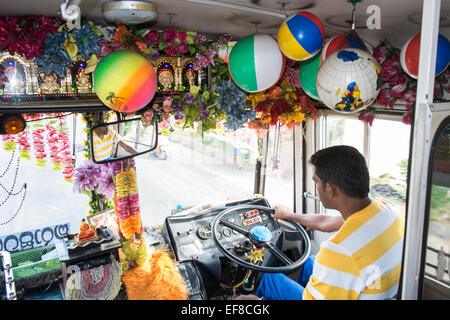 Colorato bus locale sul percorso da Hikkaduwa a Galle, Sri Lanka,statue buddiste per il culto,buona fortuna e palle da spiaggia. Foto Stock