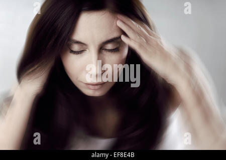 Concettuale artistico ritratto di una giovane donna con il suo mal di testa, mal di testa, il concetto di stress Foto Stock