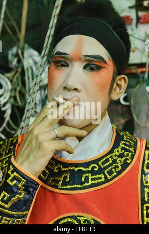 Un opera cinese performer backstage fumare durante il festival vegetariano a Bangkok, in Thailandia Foto Stock