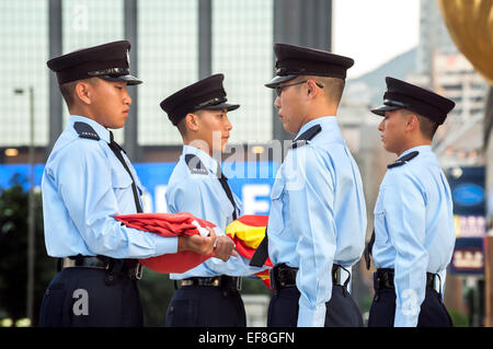 Membri della polizia di Hong Kong ha vigore eseguire il daily bandiera cerimonia di abbassamento a Hong Kong di Golden Bauhinia Square Foto Stock