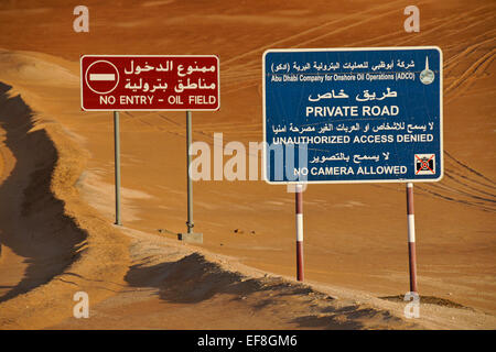 Cartelli di avvertimento accanto alla strada, Liwa dune di sabbia, Abu Dhabi, Emirati Arabi Uniti Foto Stock