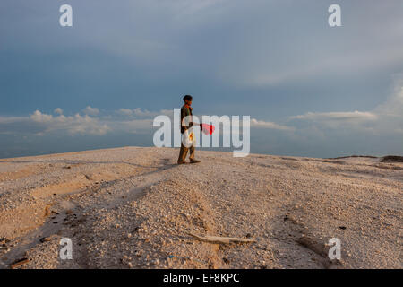 Gold Miner passando attraverso il moon-come dune a piccola scala oro tradizionale sito minerario in Hampalit, Central Borneo. Foto Stock