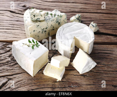 Gruppo di formaggio con stampo sul vecchio tavolo in legno. Foto Stock