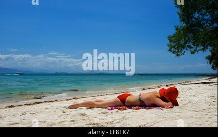 La donna a prendere il sole sulla spiaggia, Malaysia Foto Stock