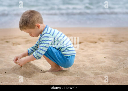 La Bulgaria, ragazzo (4-5) giocando sulla spiaggia di sabbia Foto Stock