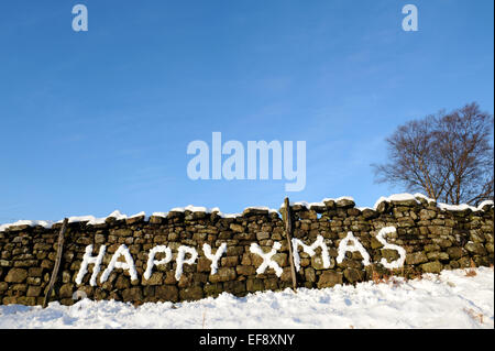 Happy Xmas 2015 scritto nella neve su un muro di pietra nello Yorkshire. Foto Stock