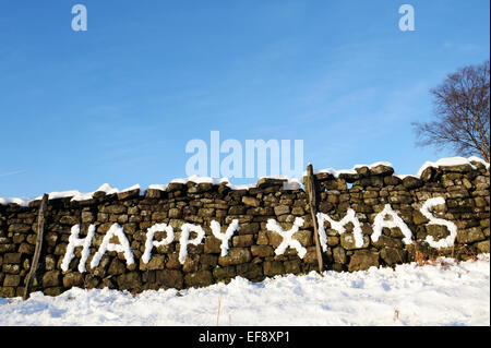 Happy Xmas 2015 scritto nella neve su un muro di pietra nello Yorkshire. Foto Stock