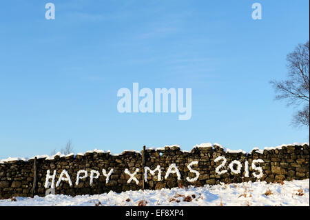 Happy Xmas 2015 scritto nella neve su un muro di pietra nello Yorkshire. Foto Stock