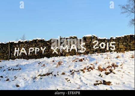 Happy Xmas 2015 scritto nella neve su un muro di pietra nello Yorkshire. Foto Stock