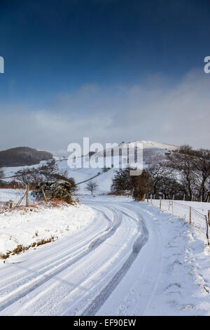 Il Gaer Pietra, Speranza Bowdler Hill, Caer Caradoc nella neve, come si vede dal Ragdon Lane, vicino a Church Stretton, Shropshire Foto Stock
