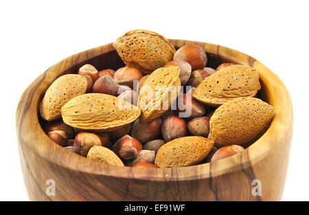 Mandorle e noci in un handmade ciotola di legno isolato su sfondo bianco Foto Stock