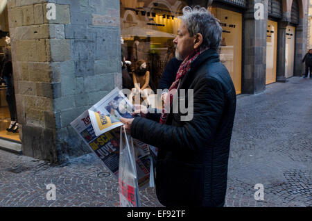 Un uomo la lettura della carta su un angolo di strada nel centro di Lucca, Toscana, Italia Foto Stock