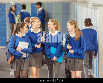 Allegro studenti femmina blu che indossano uniformi di scuola a piedi in spogliatoio Foto Stock