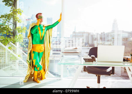 Il supereroe che parlando al cellulare in ufficio Foto Stock