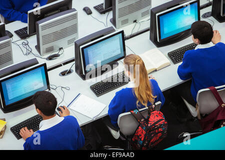 Vista in elevazione di studenti seduti e apprendimento in sala computer Foto Stock