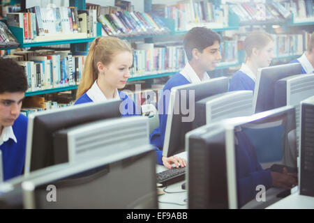 Gli studenti che lavorano su computer in libreria Foto Stock