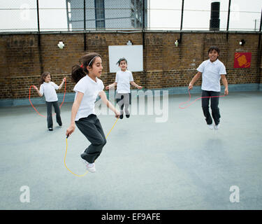 Ragazze saltando alla scuola primaria, London REGNO UNITO Foto Stock