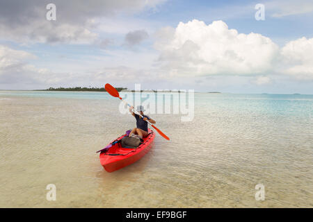 Esplorare la splendida laguna di Aitutaki in canoa. Tempesta tropicale meteo all'orizzonte. La donna la manipolazione della racchetta. Isole Cook. Foto Stock