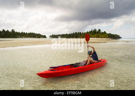 Esplorare la splendida laguna di Aitutaki in canoa. Tempesta tropicale meteo all'orizzonte. La donna la manipolazione della racchetta. Isole Cook. Foto Stock