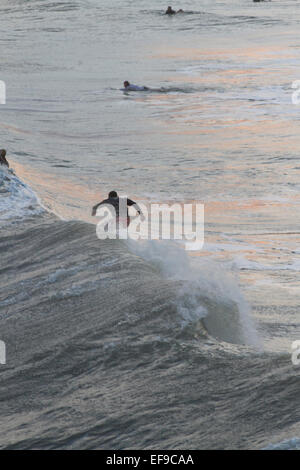 Visto dal di sopra, un surfista cavalca un potente oceano onda dall uragano Sandy come altri surfers watch Foto Stock