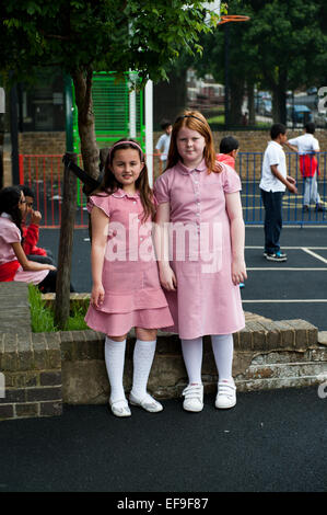 I bambini della scuola elementare indossano l'uniforme scolastica fuori nel parco giochi Foto Stock