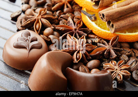 Spezie fragranti, caffè e dolci al cioccolato al buio su un sfondo a strisce Foto Stock