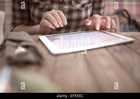 Donna in cafe la digitazione sul touch pad Foto Stock