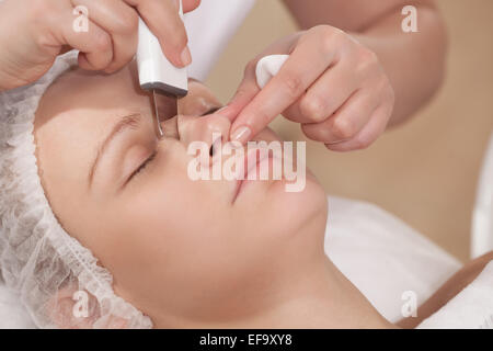Pulizia del viso con apparecchiature ad ultrasuoni in corrispondenza di un trattamento di bellezza salon Foto Stock
